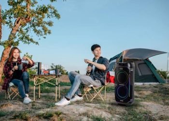 Foto 1 dua anak muda bersantai sambil menikmati alunan musik dari portable party speaker sharp