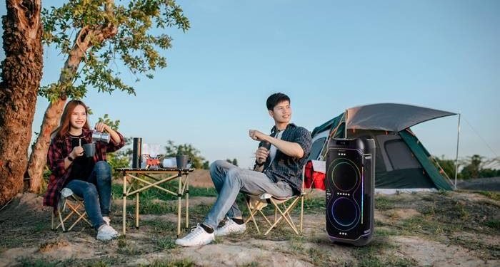 Foto 1 dua anak muda bersantai sambil menikmati alunan musik dari portable party speaker sharp